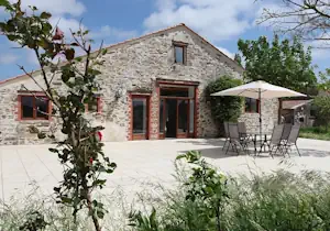 Patio of La Salle des Fêtes, an outdoor space with seating and natural light, ideal for events and gatherings